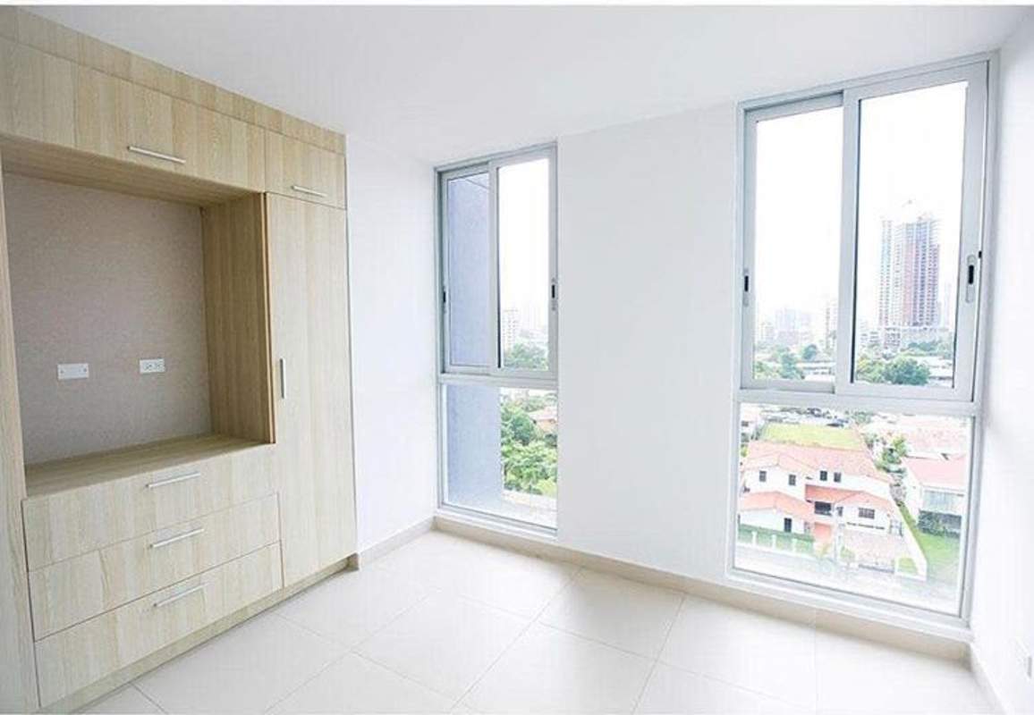 Bright bedroom with large window and built-in wardrobe facing city view at PH Residencial Herbruger El Carmen