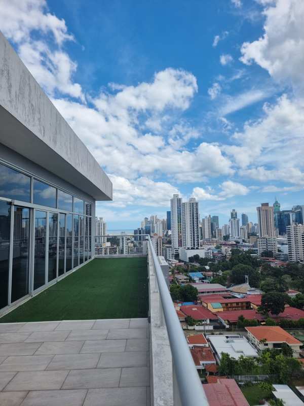 Balcony with glass railing and city skyline views of Panama City at PH Residencial Herbruger