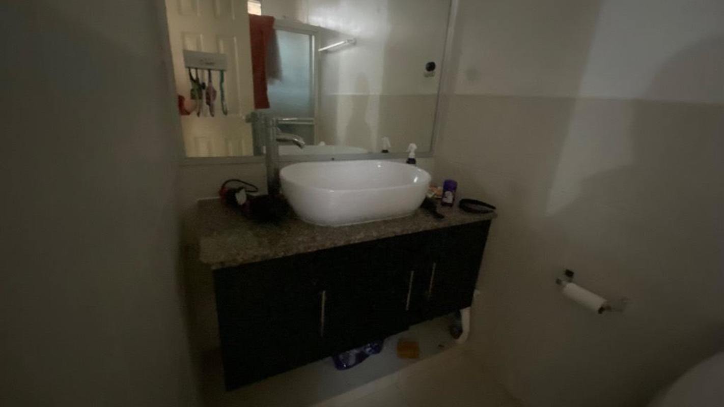Bathroom with peach walls, ceiling fan, shower, wood vanity and mirror Camino Real III Panama