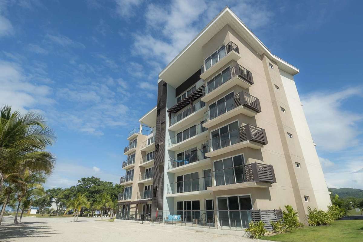 Contemporary beachfront condominium building with balconies and glass railings at Olas del Mar Punta Chame