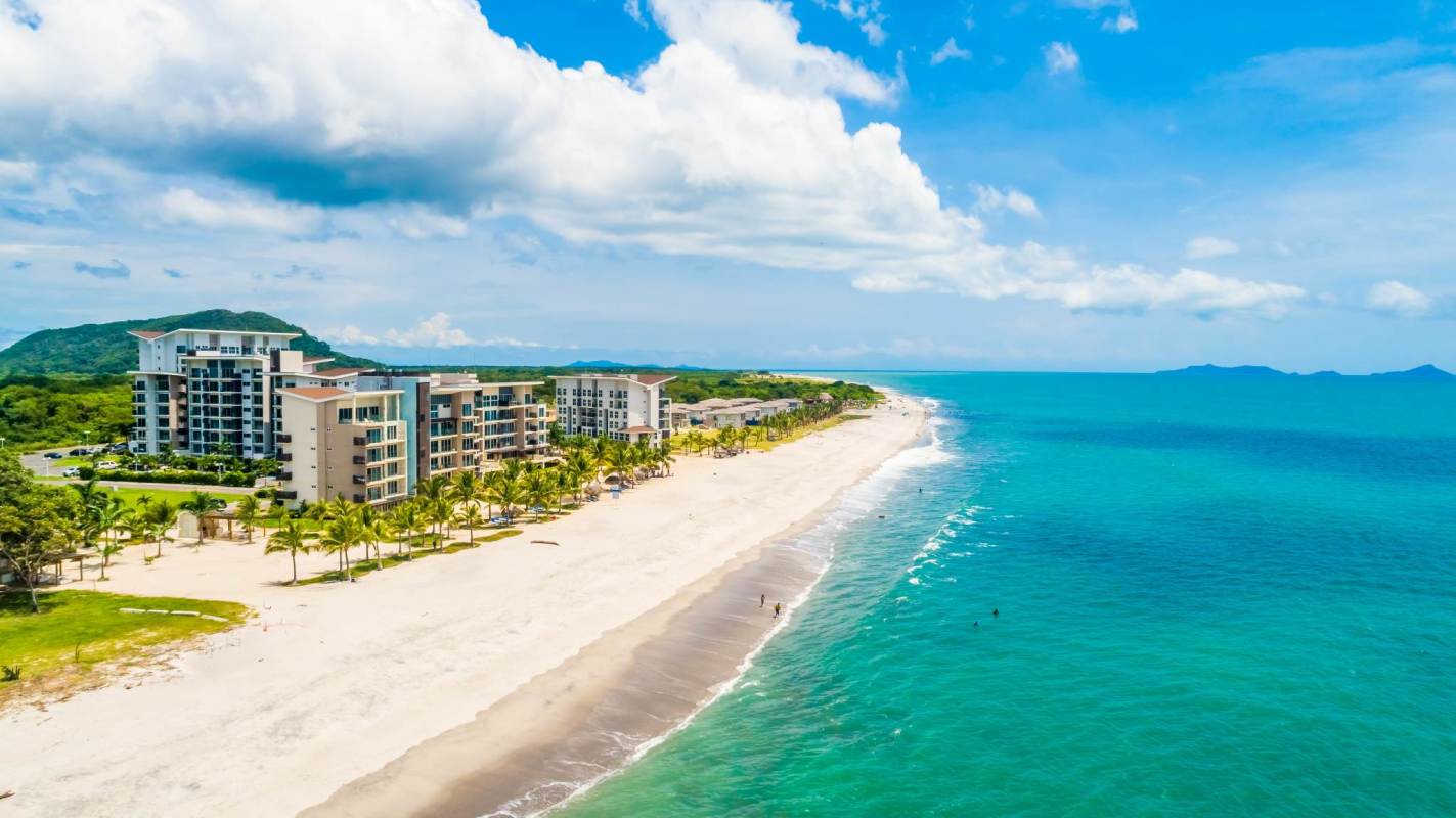 Aerial view oceanfront condos tropical beach and hills Playa Caracol Panama