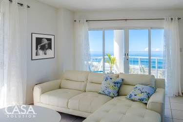 White high-rise beachfront condo tower Las Olas amidst palm trees at Playa La Barqueta Chiriquí Panama