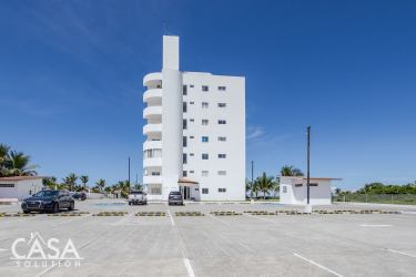 Spacious oceanfront balcony with glass railing blue chairs palm trees view in Las Olas Tower Playa La Barqueta Panama