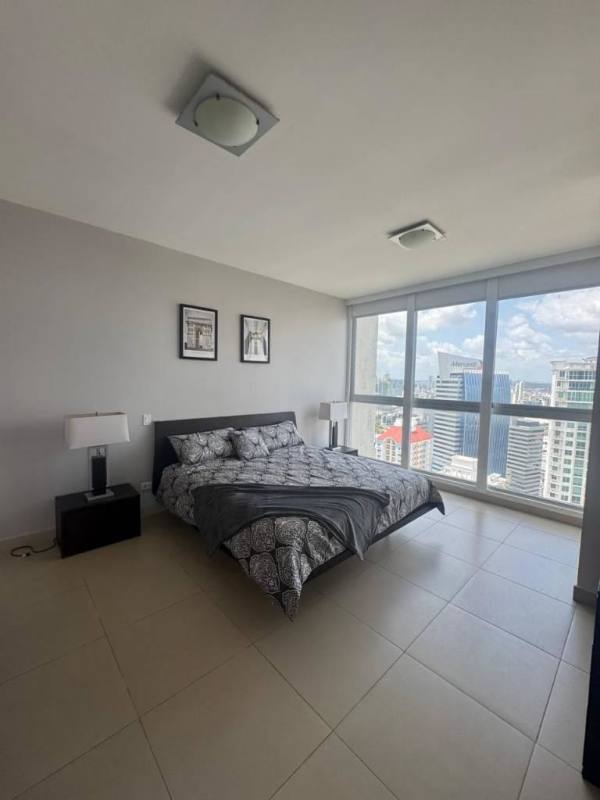 Modern bedroom with floor-to-ceiling windows and city skyline views at PH Oceanaire Panama