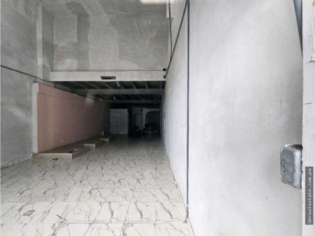 Commercial storefront glass doors open to busy street in Obarrio, Panama City