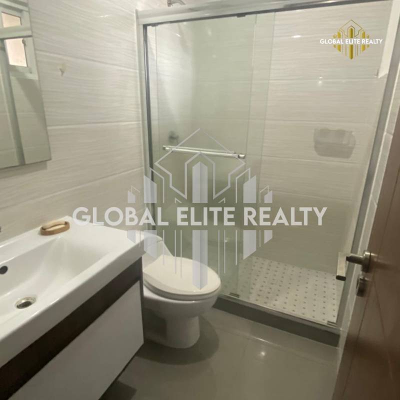 Modern bathroom with glass shower, vanity, mirror in apartment for sale PH La Riviera Panama