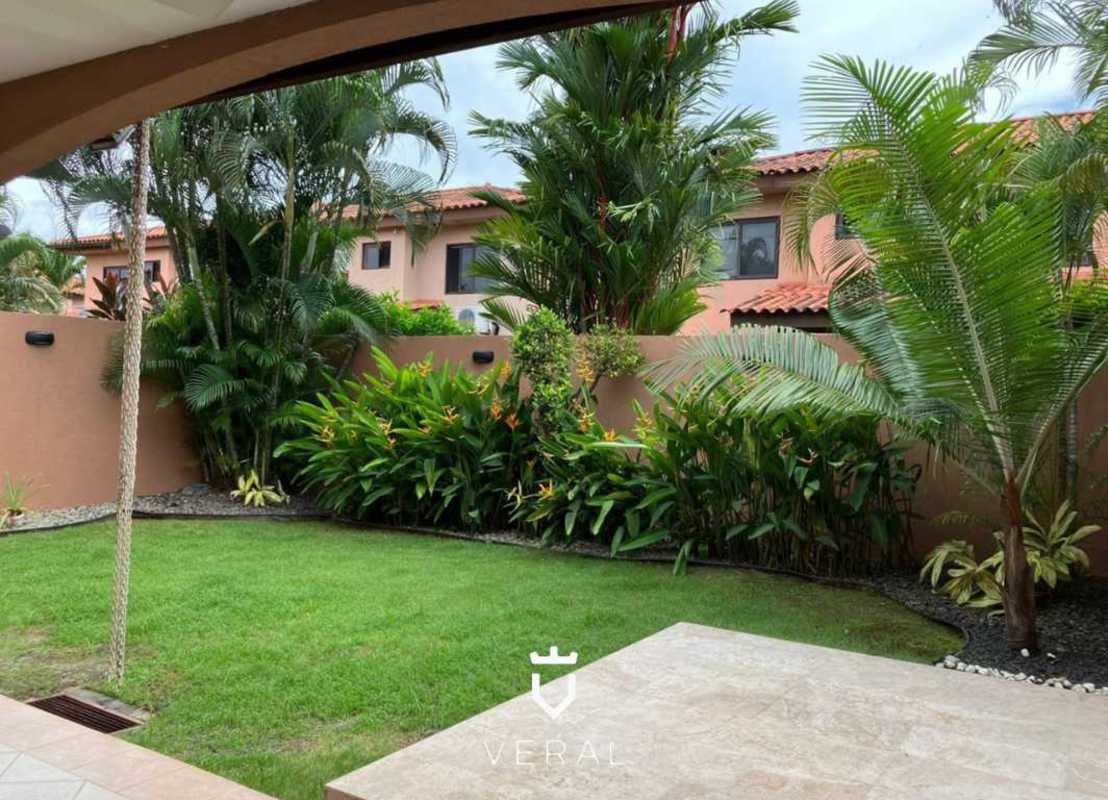 Covered terrace with landscaped garden overlooking suburban homes in Panama