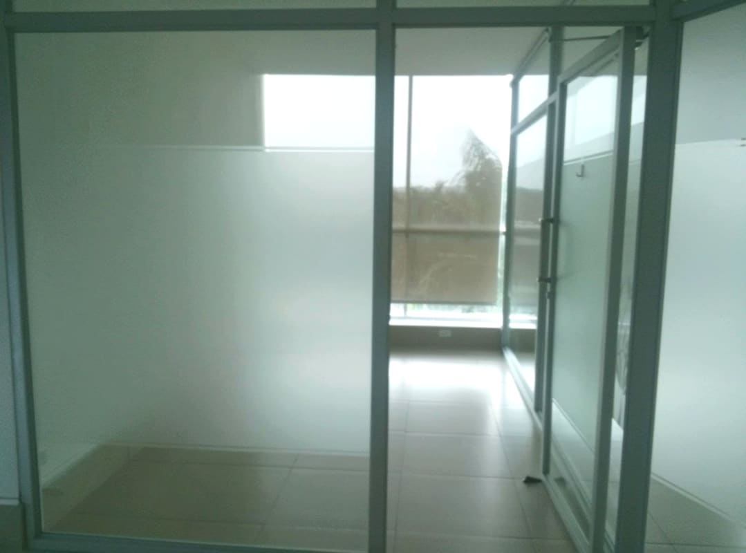 Office interior with glass partitions, natural light windows, neutral tile floor at Top Tower Costa del Este Panama