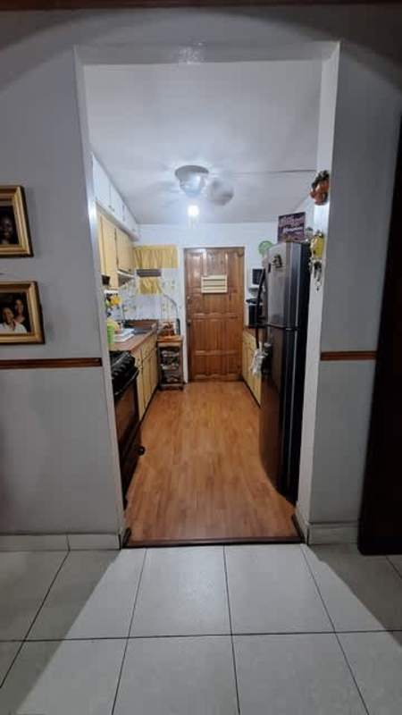 Living room with wood ceilings, brown sofas, chandeliers in Parque Lefevre home for sale
