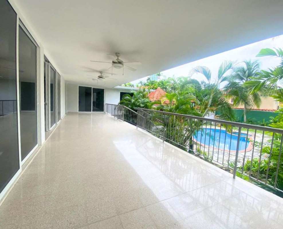 Spacious covered balcony terrace with ceiling fans, garden and pool view in luxury Altos del Golf villa Panama City