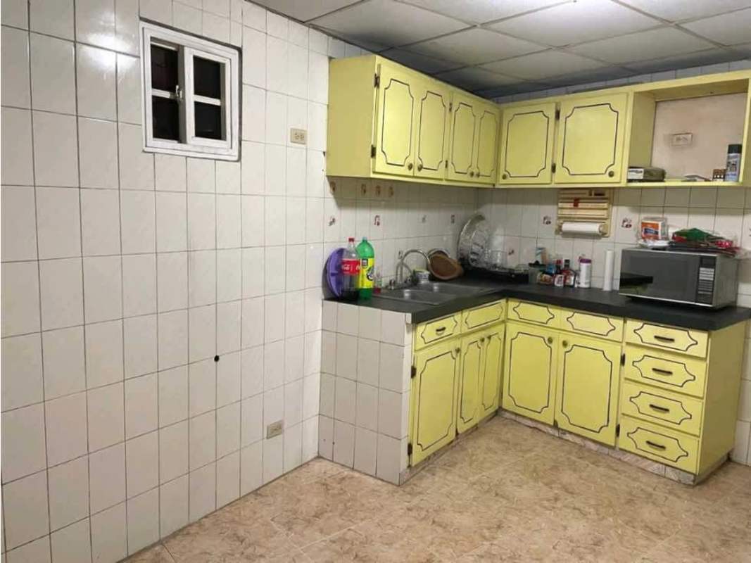 Kitchen with yellow cabinets, black counters, tiled walls in Hato Pintado Panama City rental