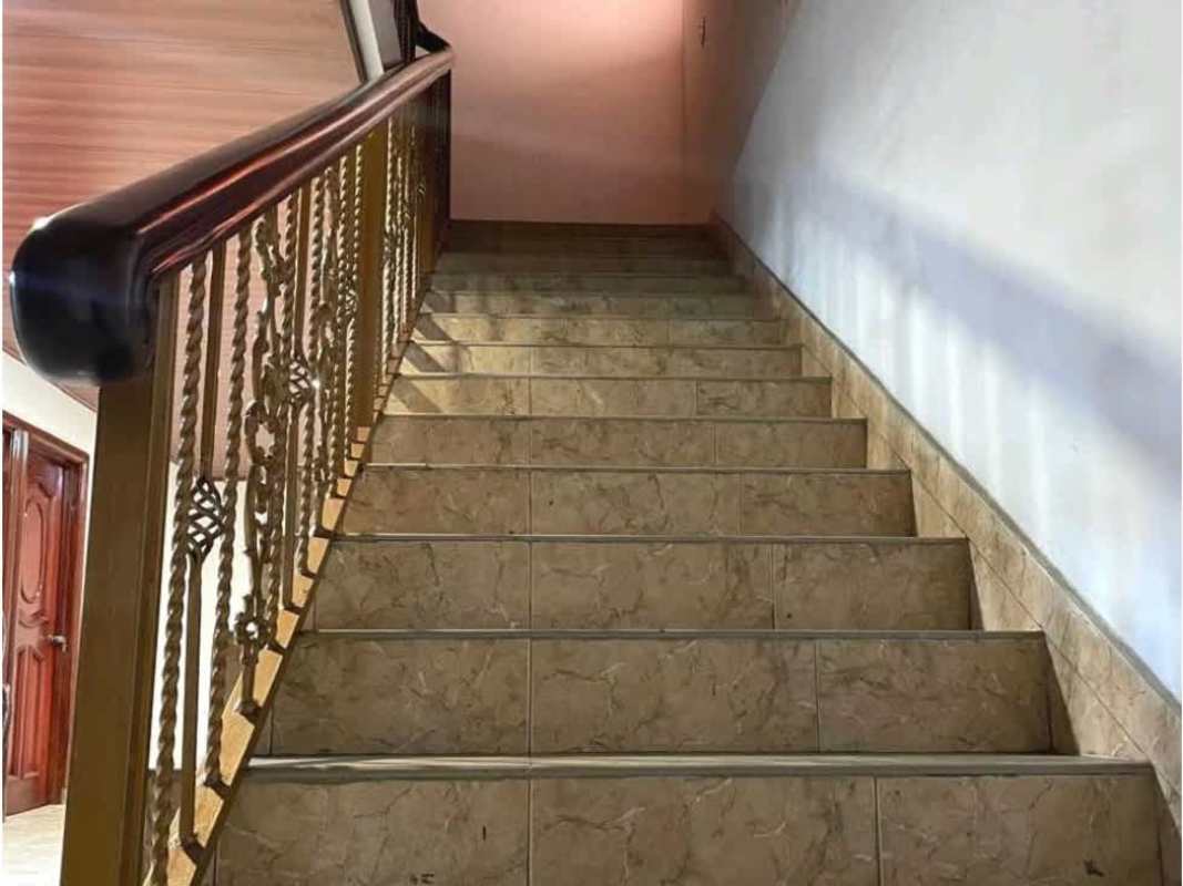 Hallway with wood paneled ceiling, tile floor, brass stair railing at rental house Hato Pintado Panama