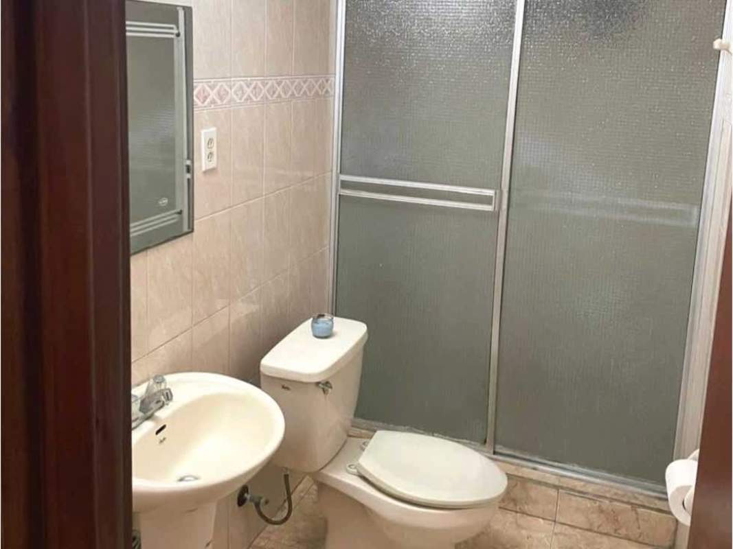 Bathroom with pedestal sink, toilet, glass sliding shower enclosure Hato Pintado rental house Panama