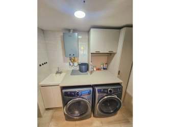 Custom walk-in closet with built-in shelves, glass vanity top, and ottoman stool at Panama Pacifico apartment
