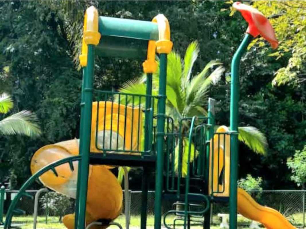 Children’s playground with slides and climbing structures in green surroundings at PH Embassy Gardens Clayton Panama City