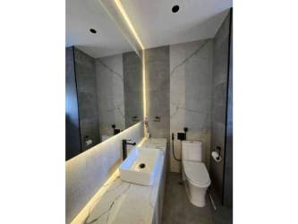 Minimalist bedroom with floor to ceiling ocean views and marble flooring in Panama City