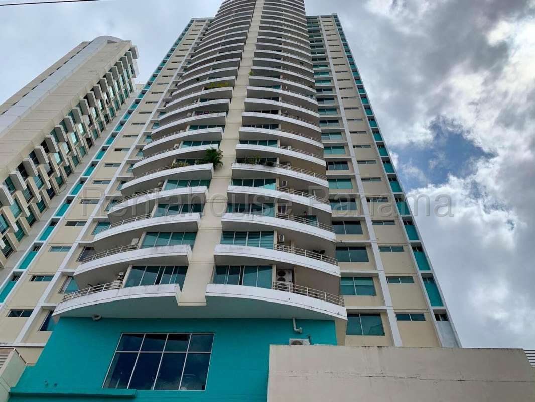 Spacious open-plan living and dining room with floor-to-ceiling windows overlooking Panama City