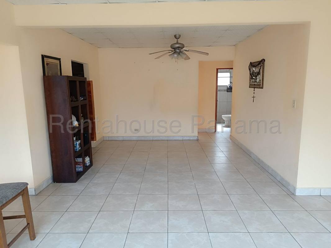 Covered outdoor patio with green yard and mature trees at Betania house Panama