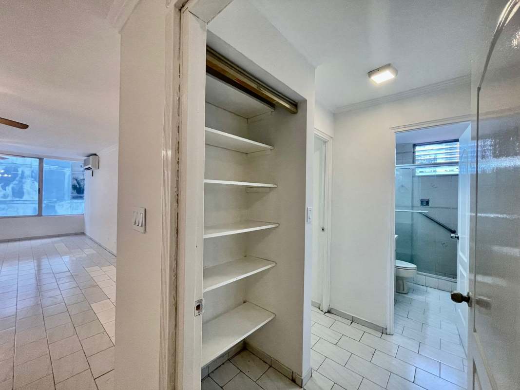 Bright hallway with built-in shelving and view towards living room and bathroom PH Ocean View Panama