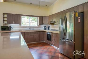 Contemporary kitchen with large windows, L-shape counters, stainless appliances at Boquete home