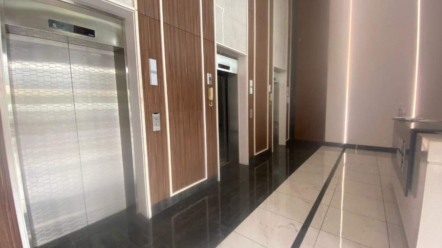 Lobby with elevator bank and wood paneling at Millenium Park Plaza office building in Panama City