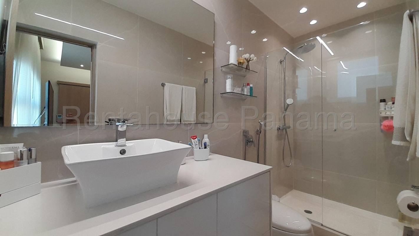 Modern bathroom with glass-enclosed shower and marble accents in penthouse PH South Coast Tower Panama