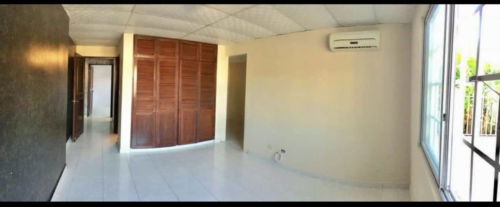 Bedroom with built-in closet and window in house Las Cumbres Panama