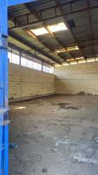 Empty open plan warehouse interior with concrete floors and high ceilings in Puerto Armuelles Chiriquí for lease
