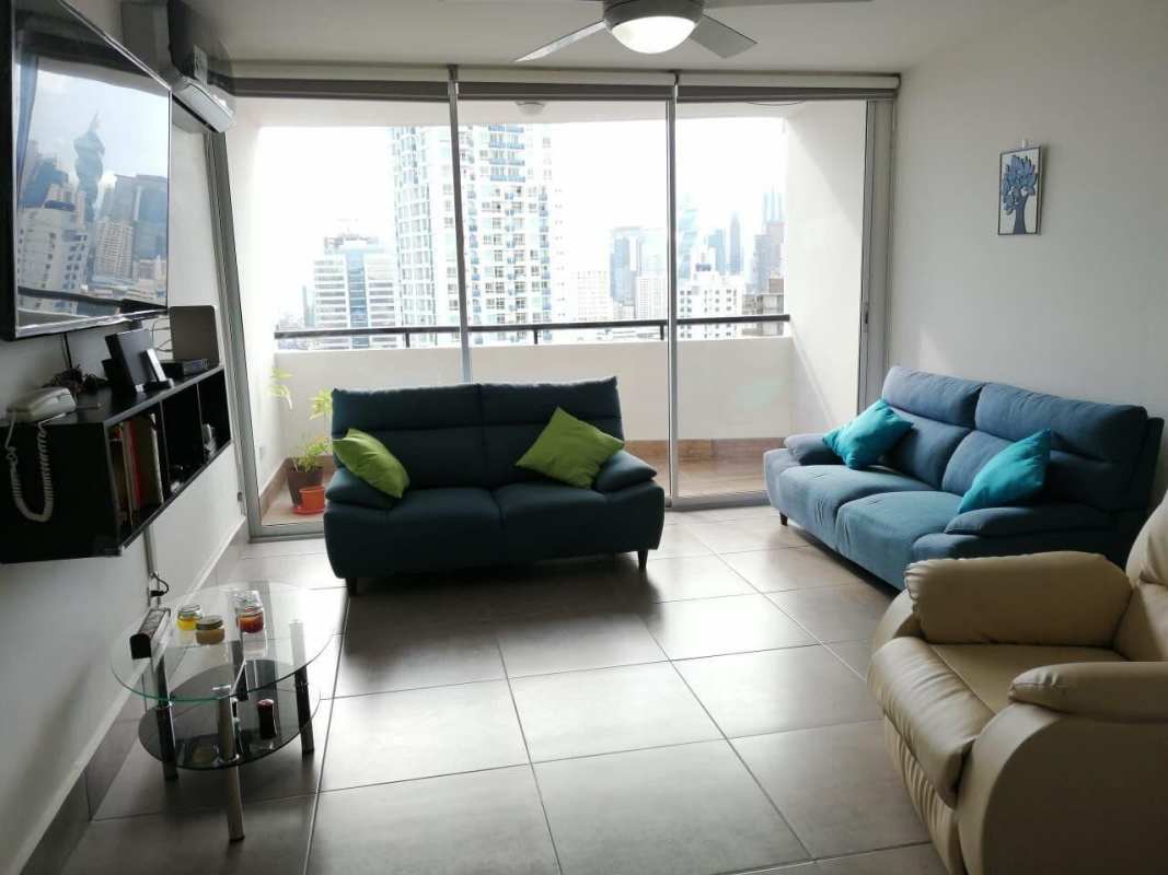 Living room with sliding doors to balcony and city views at PH El Carmen Panama City