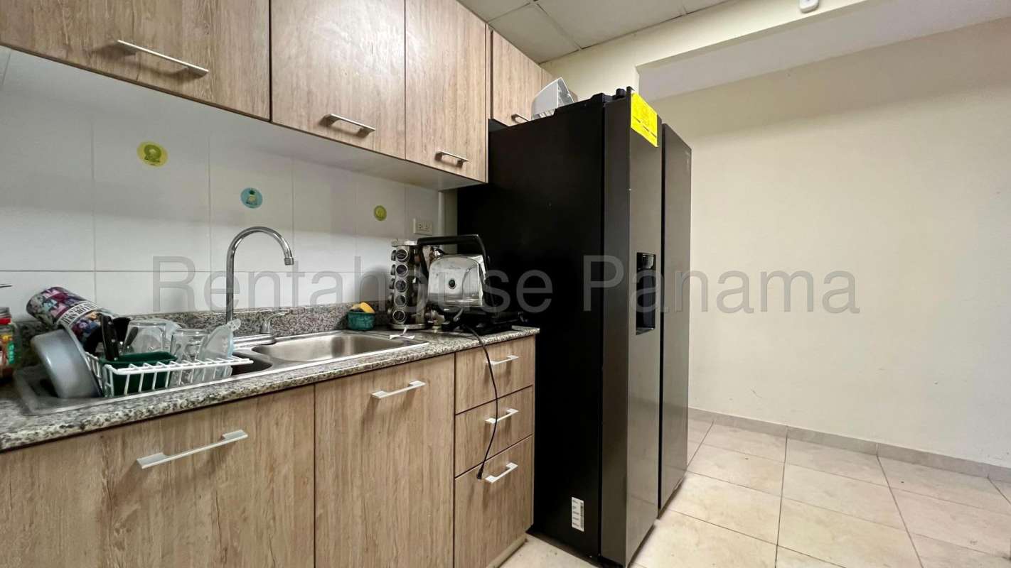 Kitchen with granite countertop, wooden cabinets and appliances in PH Colinas del Lago, Las Cumbres Panama
