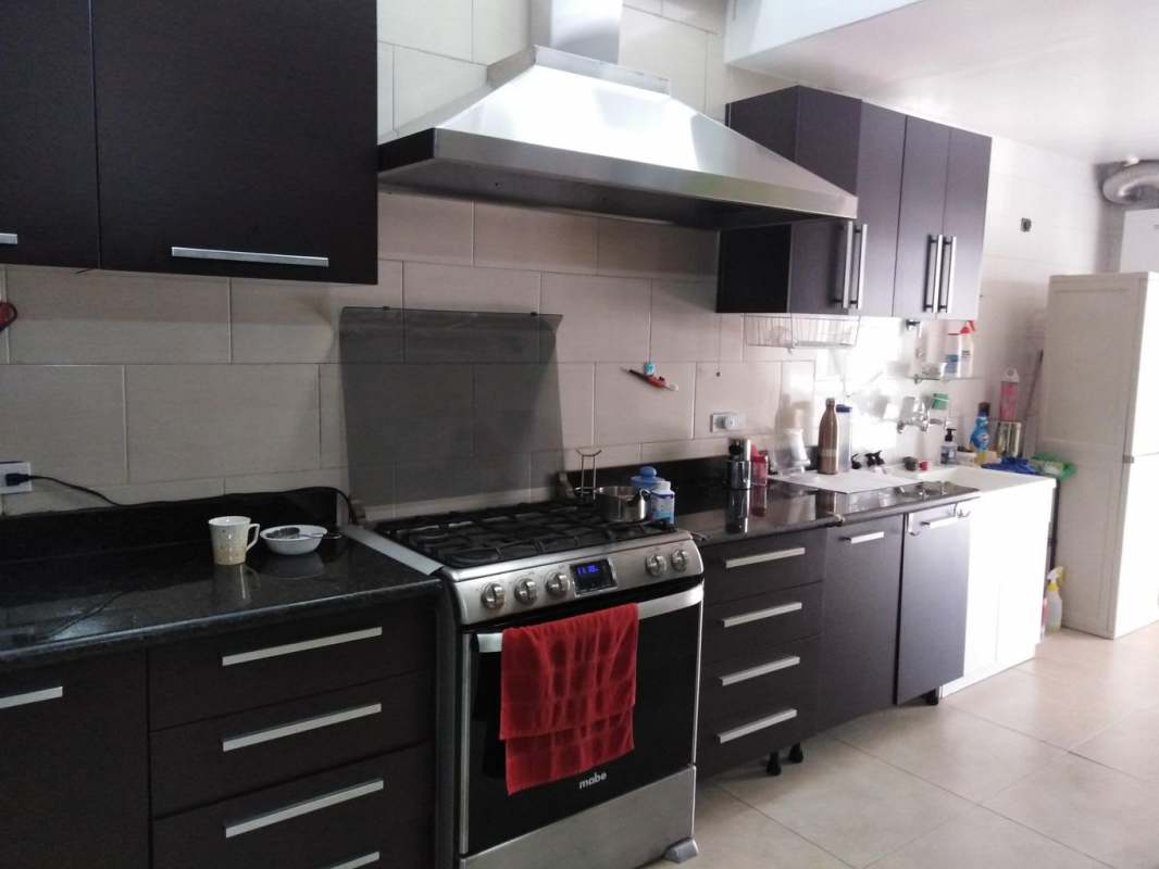Spacious bedroom with turquoise walls, dresser, mirror and tiled floor Altos de Panamá
