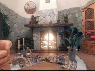 Living room in country estate featuring stone fireplace, wood furniture in El Valle Panama