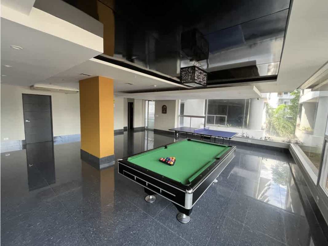 Outdoor swimming pool on high-rise building with sun loungers skyline backdrop at El Cangrejo Panama