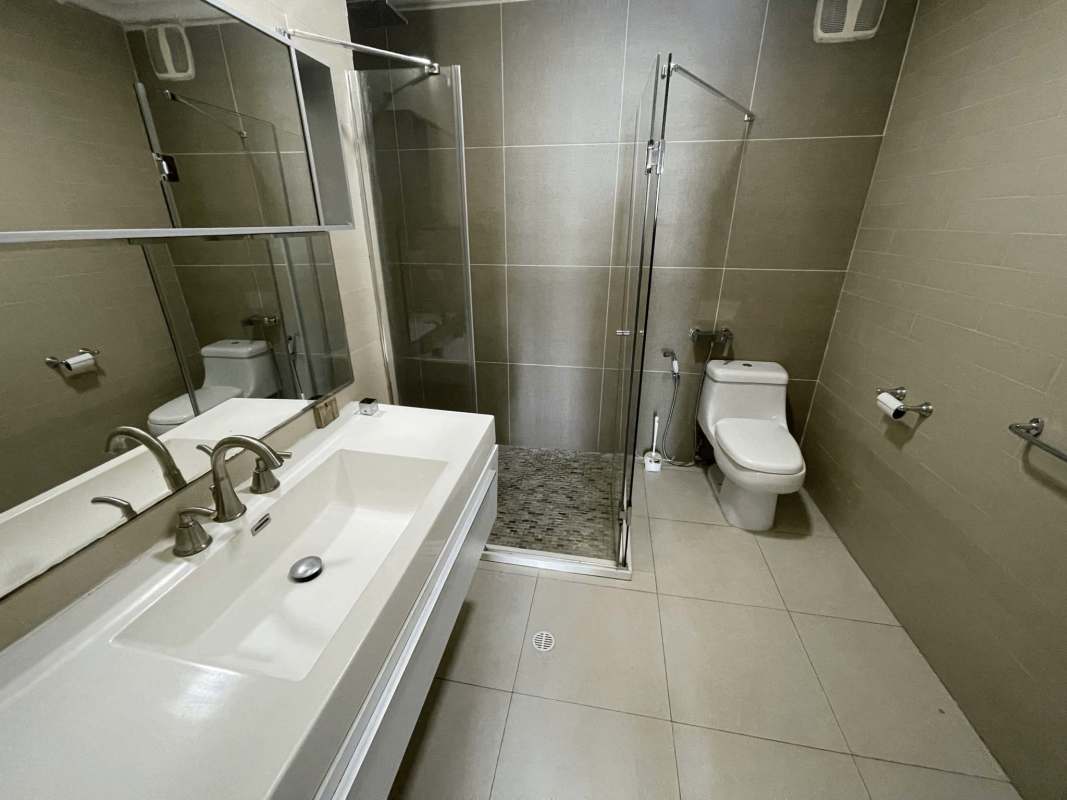 Second bedroom with twin beds and city skyline view in PH Waters Avenida Balboa