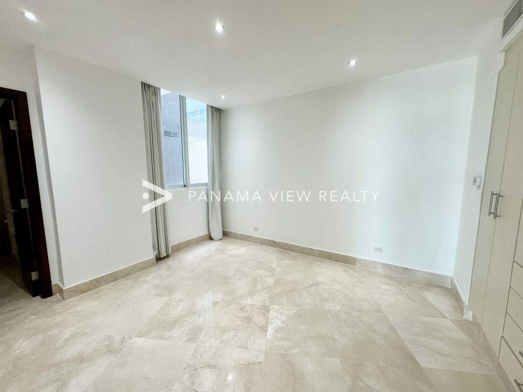 Elegant bathroom in Punta Paitilla apartment with marble tiles and glass shower