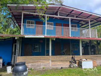 Two-story rustic farmhouse with balcony, metal roof, and traditional tropical style in Chiriquí Panama