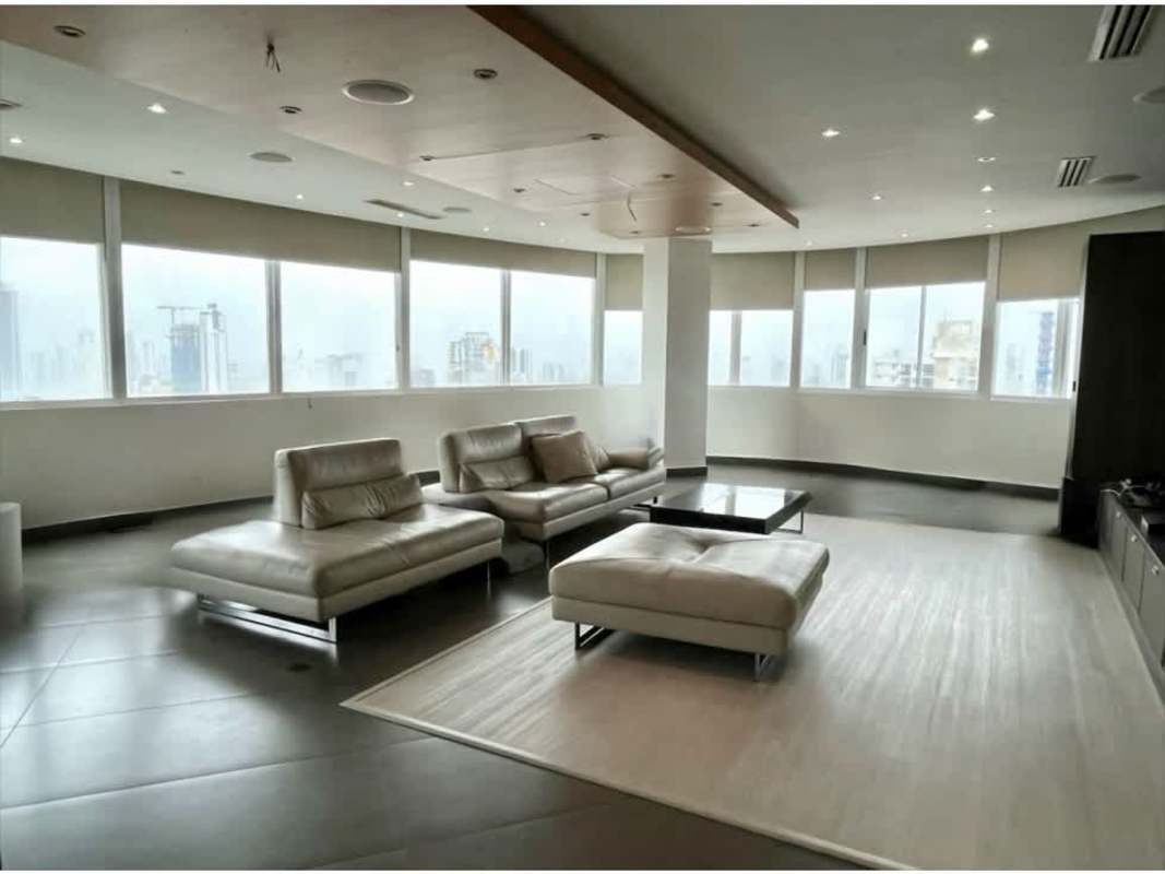 Spacious modern living room with panoramic windows, leather sofas, city skyline view in triplex penthouse Panama City