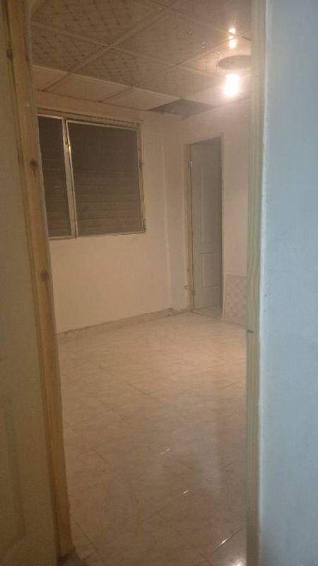 Empty studio with tiled floor, patterned ceiling tiles, window shutters, door in PH Park Lefevre Chanis Panama