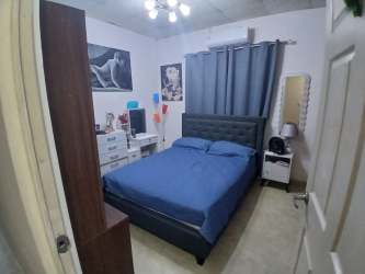 Bedroom with blue bedding, upholstered headboard, modern design Colón Panama