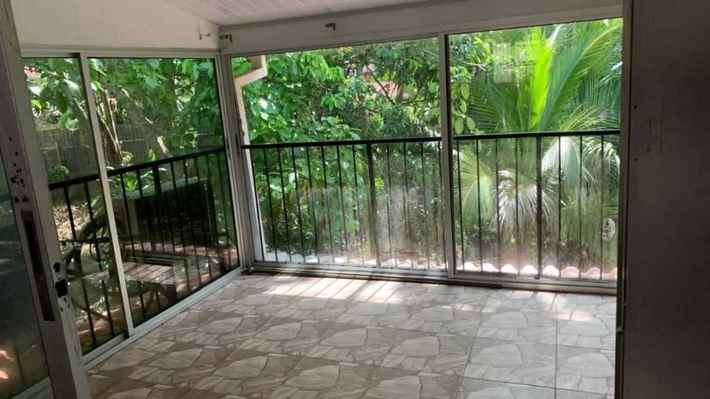 Sunroom with sliding glass doors black railings overlooking garden Clayton Panama residential