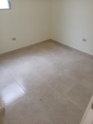 Empty tiled living room with access to bedrooms and kitchen in Lago Emperador Arraiján