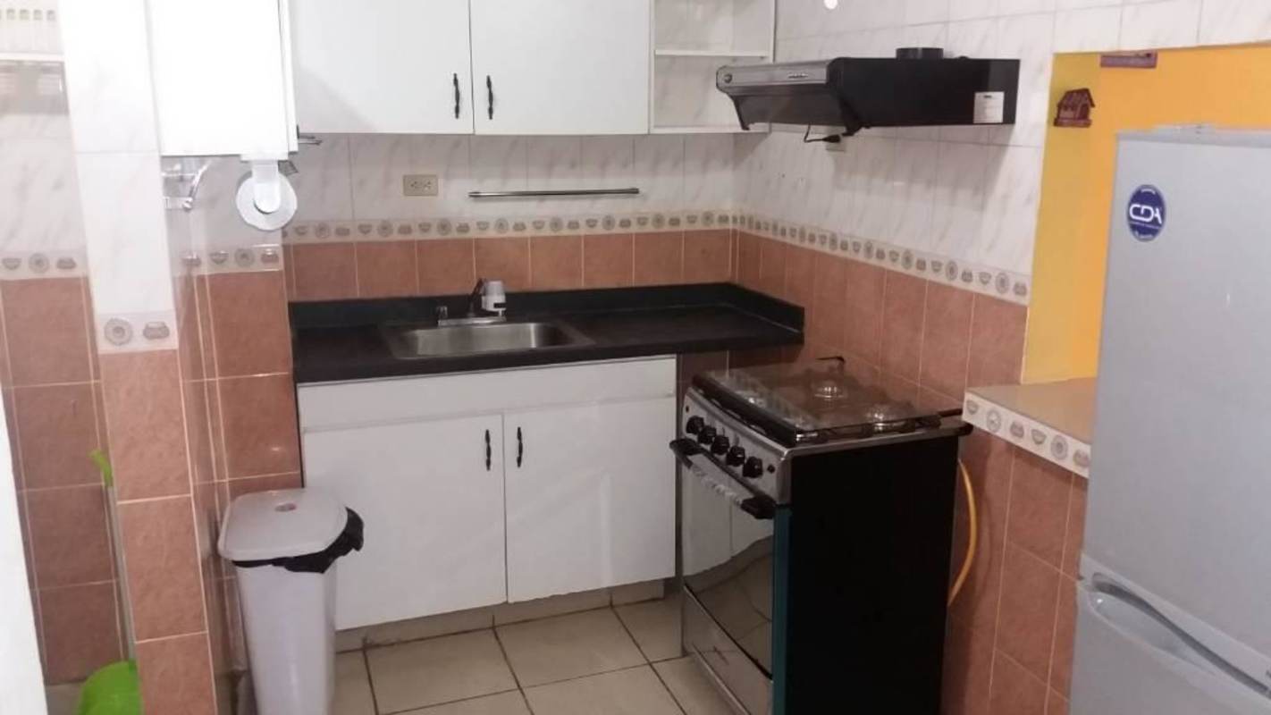 Functional kitchen with stove, fridge and tile backsplash in PH Río Pison Betania Panama apartment