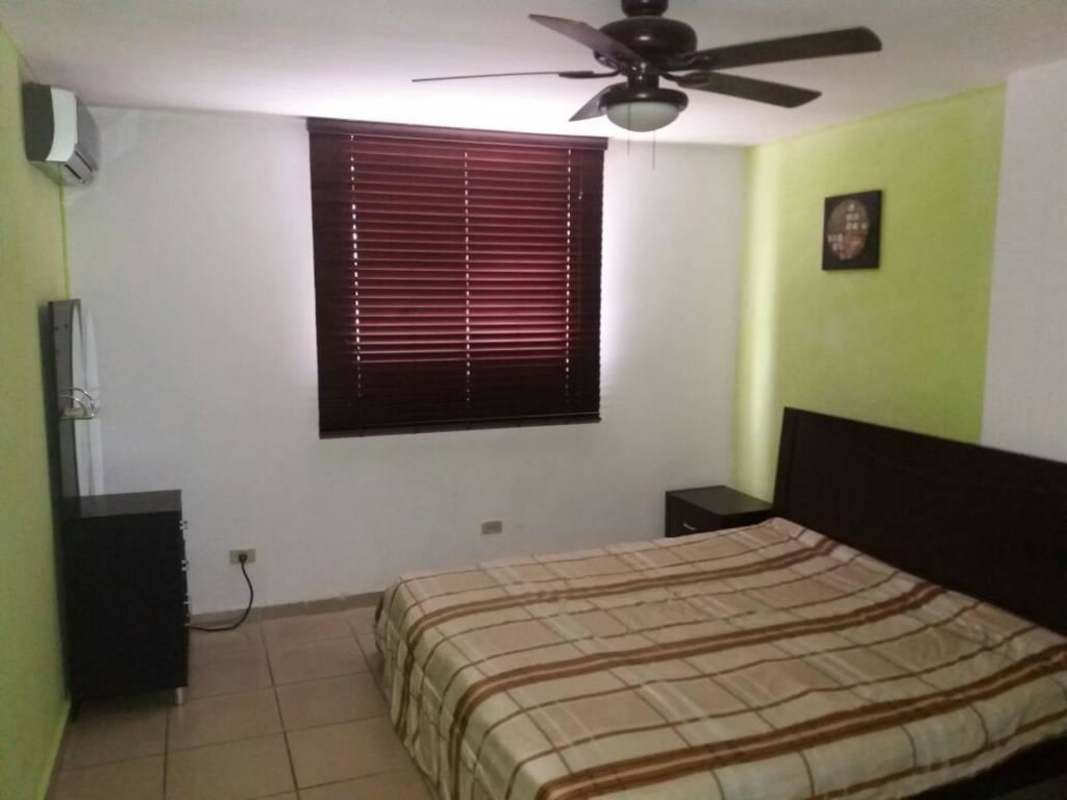 Master bedroom featuring green accent wall, AC unit, ceiling fan, tiled floors in PH Río Pison Betania Panama