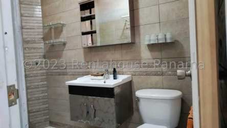 Contemporary bathroom with wall tiles, vanity, mirror, and modern fixtures in La Chorrera house