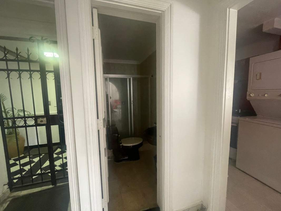 Galley kitchen with red tiled walls white cabinets stainless refrigerator PH Las Hadas Panama