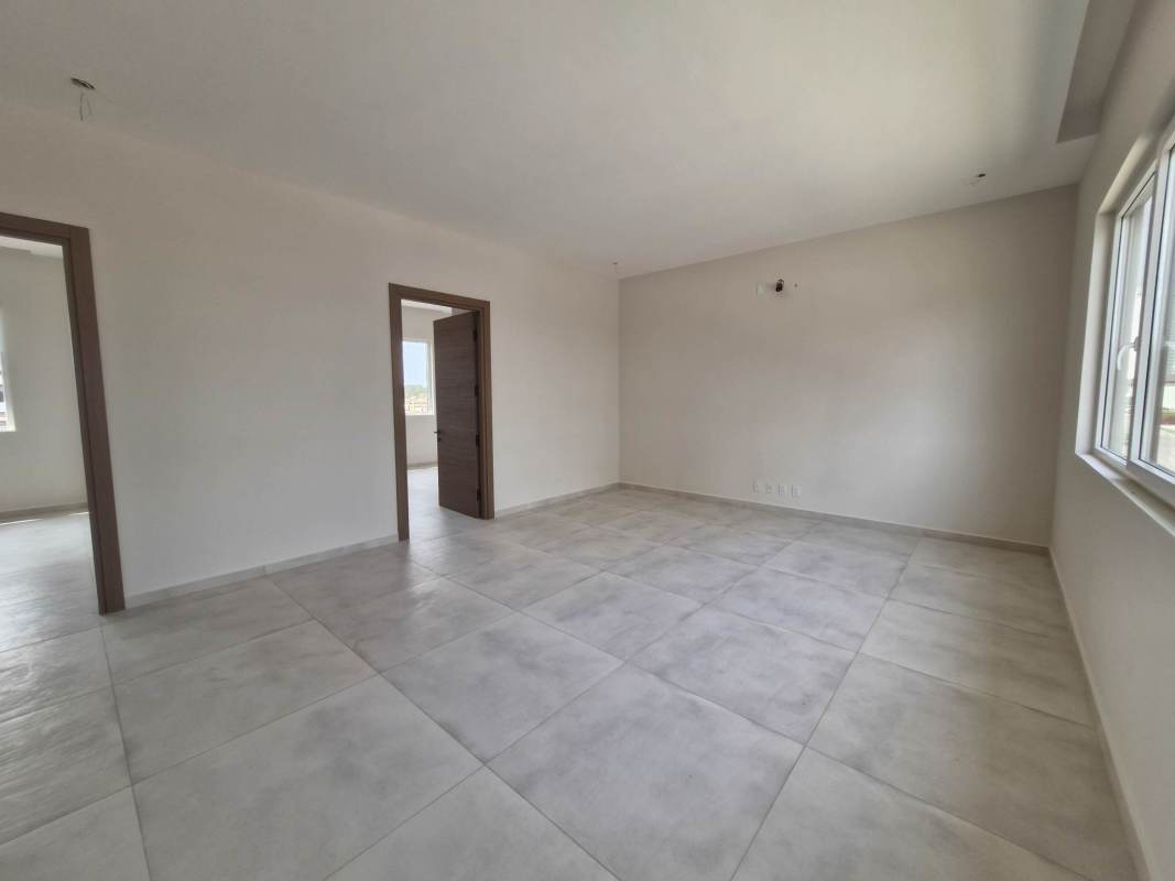 Bright open-plan living and dining room with garden views at THE WOODS Santa María Panama