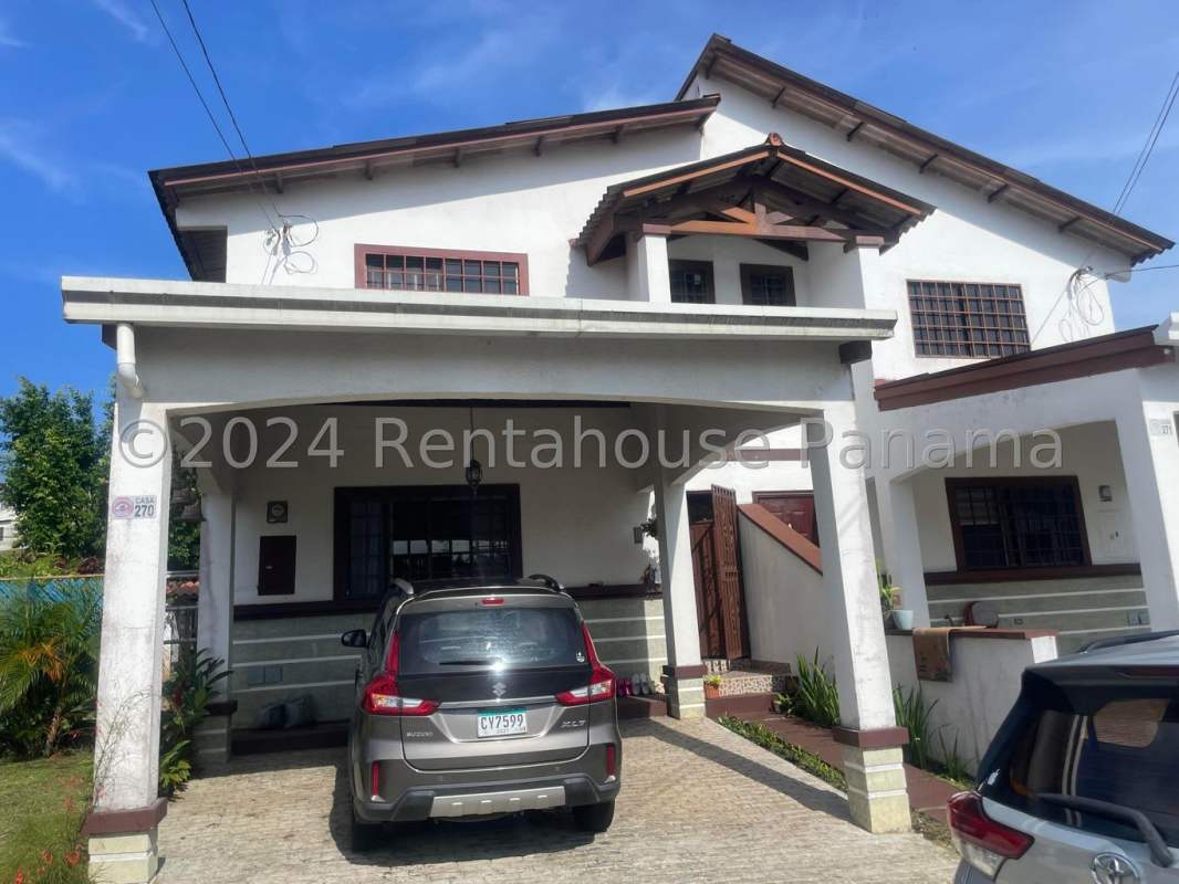 Two-story house exterior with carport and garden PH Las Cumbres Panama City for sale