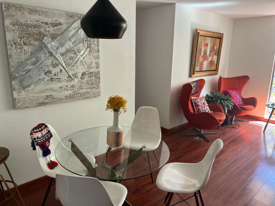 Spacious living and dining room with large windows, glass dining table and colorful accents at PH Pacifica Park