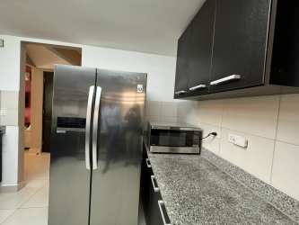 Living room with sofa set, burgundy accent wall, TV and AC at Woodlands Panama Pacifico house