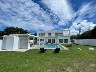 Modern double-height living room with large windows near Playa Malibu Panama